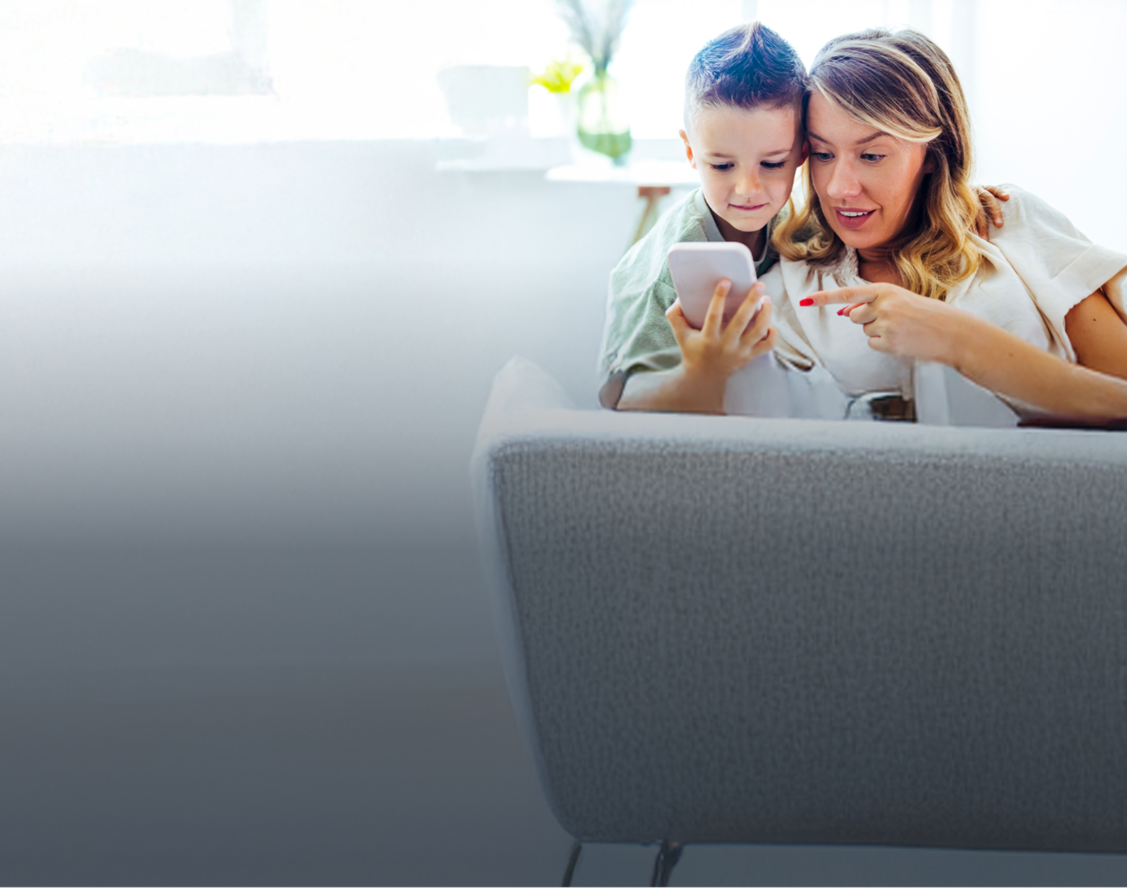 Mutter und Sohn schauen auf ein Handy und nutzen eine SIM-Karte für Kinder.