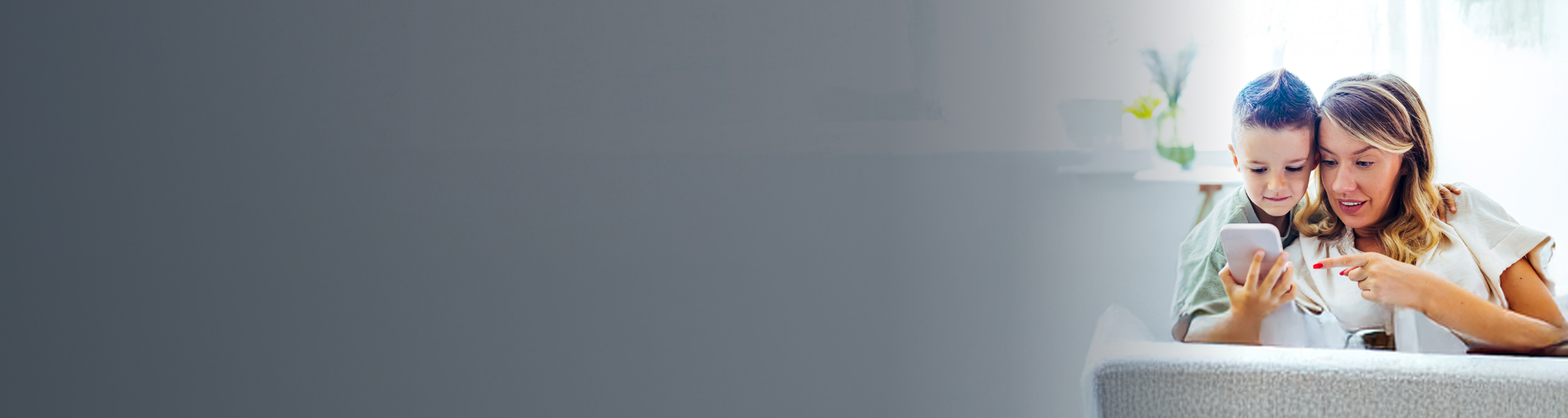 Mutter und Sohn schauen auf ein Handy und nutzen eine SIM-Karte für Kinder.